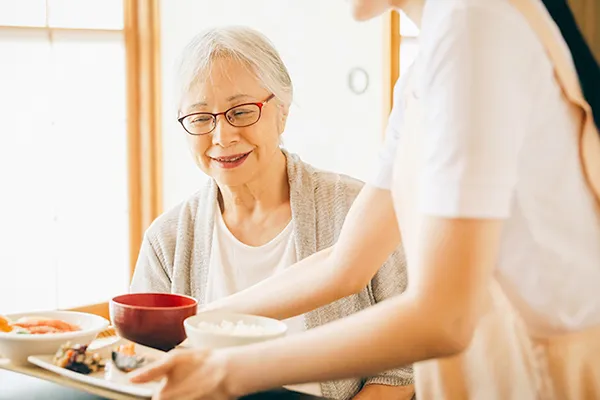 食事の補助を受ける女性